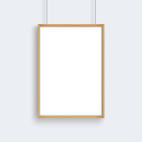 Деревянная рамка с макетом плаката висит на серой стене
.