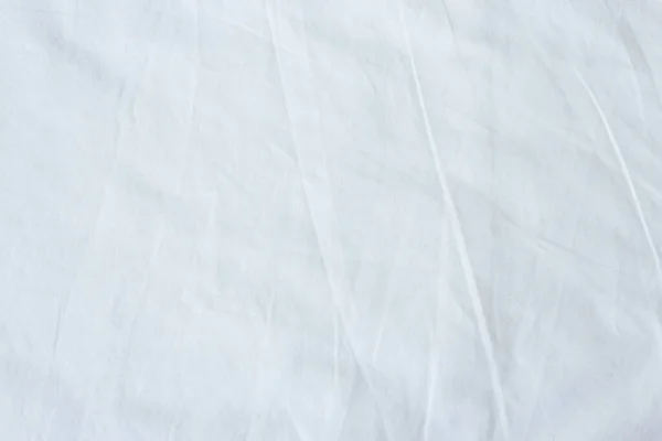 Top view of white fabric bed sheet texture background.