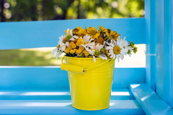 Bucket of flowers on a wooden box