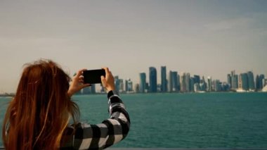 Kız Doha Qatar akıllı telefon ile gökdelenler için fotoğraf çekmek