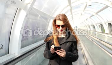 Kız Metro merdivenlerde cep telefonu üzerinde manifatura