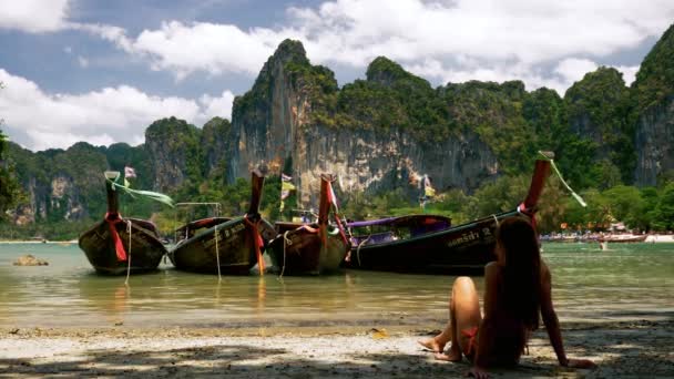 Menina relaxante perto de tailandesas de cauda longa barcos na praia tropical — Vídeo de Stock