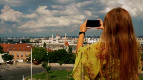 Chica turística tomando fotos en el edificio del parlamento de Budapest — Vídeo de stock