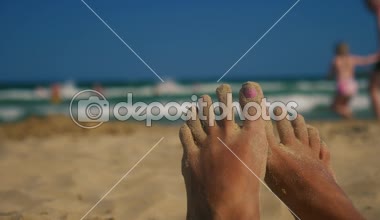 Parmaklarında kum ile plajda tembel ayaklar