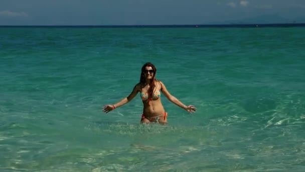 Chica feliz jugando en una clara olas de agua azul cámara lenta — Vídeos de Stock