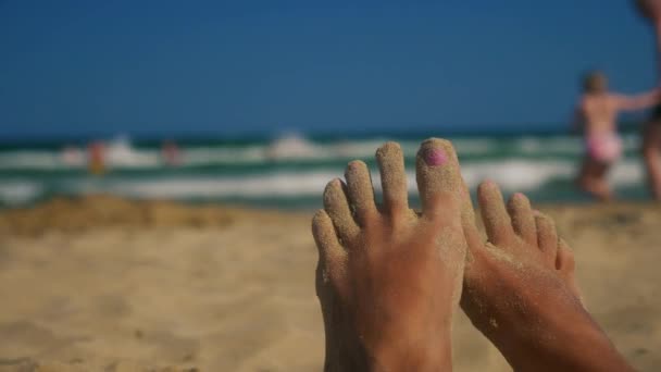 Pieds paresseux sur la plage avec du sable sur les orteils — Video