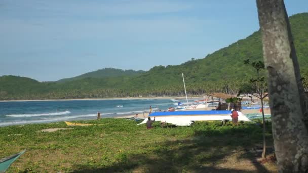 Gente reparando un barco en una hermosa playa tropical en las Filipinas — Vídeo de stock