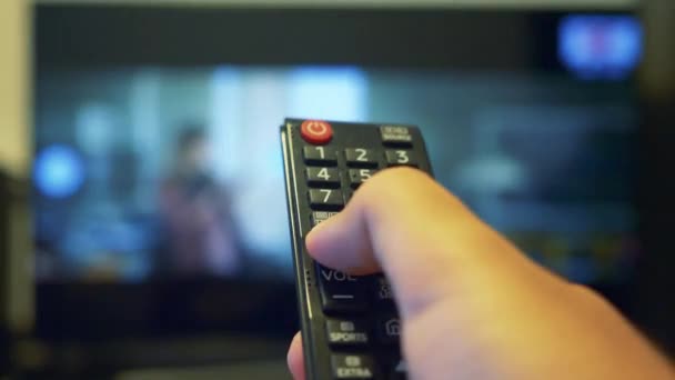 Usando el control remoto de la televisión y presionando el botón de volumen — Vídeo de stock