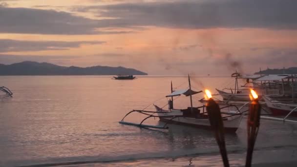 Romantische zonsondergang op het strand met fakkels in de Filipijnen — Stockvideo