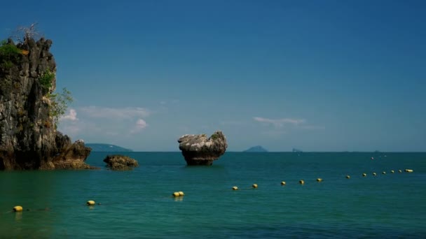 Traditional thai long tail boat passing near rock formations on the sea — Stock Video