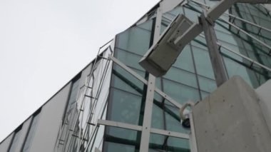 Modern bir ofis binasının önünde iki gözetleme kamerası