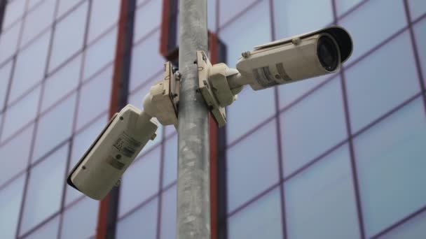 Deux caméras de surveillance sur le poteau de lumière devant le bâtiment de bureau — Video