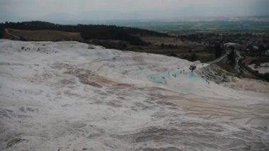 Beyaz havuzlar ve güzel bir manzara var. Pamukkale turist yerinde, hindinin içinde..