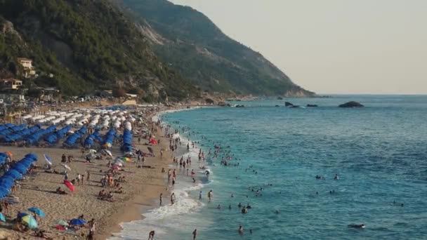 Bardzo Piękna Plaża Turystami Bawiącymi Się Falach Wieloma Parasolami Leżakami — Wideo stockowe