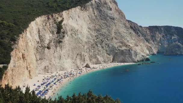 観光客と岩の崖のギリシャの近くに青い水と非常に美しいビーチ 観光広告のための完璧なショット — ストック動画