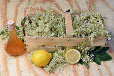 Ahşap zemin üzerinde mürver çiçeği şurubu ve taze çiçek