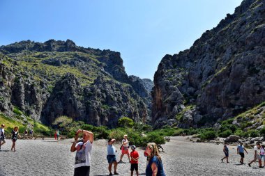 Sa Calobra'da turistlerin arasında dinlenin