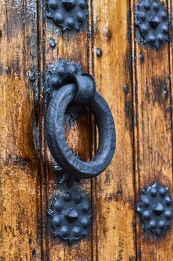 Tahta bir kapının üstünde klasik bir el tokmağı.