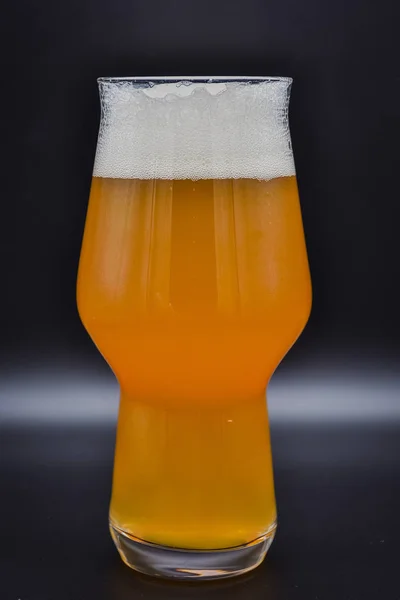 glass of beer on black background, filled glass, drink on black