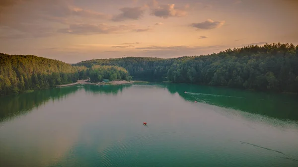 Orman ve göl günbatımı sırasında dron görünümü.