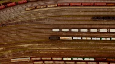 Tren istasyonunda mal ile renkli yük trenleri havadan görünümü. Uçan drone'dan en iyi görüntü