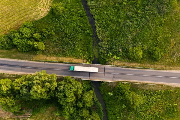 Drone, küçük nehir üzerinde uzak yol sürüş kamyon yukarıdan aşağıya görünümü — Stok fotoğraf