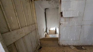 Terk edilmiş bina içi, soyulmuş boya ve yıpranmış merdivenler. Suriye, Sednaya Cezaevi.