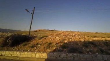 Kırsal bir arazide gün batımı ve uzak tepeler. Suriye