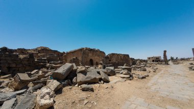 Eski kalıntılar berrak mavi gökyüzünün altında dağınık taşlar ve eski yapılar. Antik Dara şehri, Suriye.