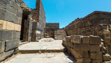 Açık mavi gökyüzünün altında basamakları olan antik taş kalıntıları. Antik Dara şehri, Suriye.