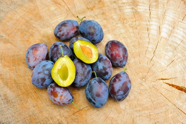 stock image Fresh plums on a wooden plate in the garden in autumn