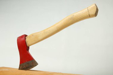 Beyaz bir arka plan üzerinde izole ahşap Pano içine sıkışmış kırmızı balta.