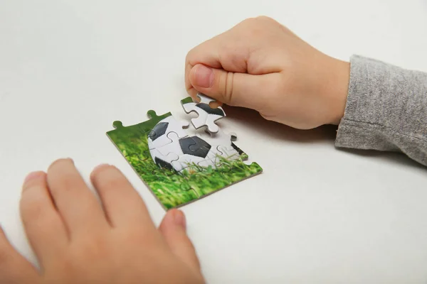 Die Hände Eines Kindes Fügen Ein Puzzle Mit Einem Fußball — Stockfoto