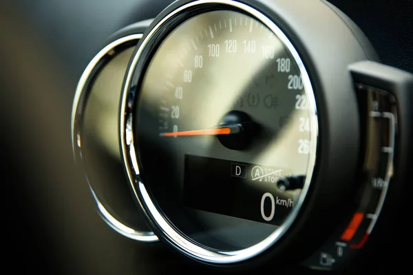 analog speedometer with digital screen in the car close-up. glare of light on the glass of the car speedometer