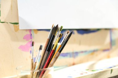 Şövalenin arka planında resim yapmak için eski fırçalar