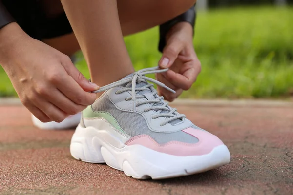 Kadın ayakkabısına ayakkabı bağcığı bağlıyor. Yakından.