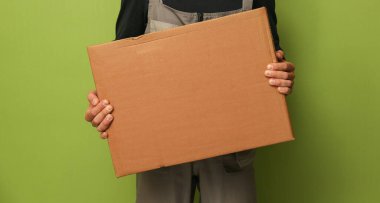 Karton kutu tutan bir yükleyici. Teslimat servisi çalışanı bir kutu tutar.