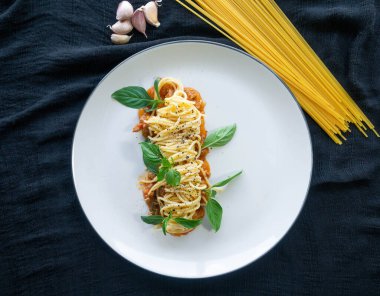 Domates soslu spagetti, Domatesler, kıymalı domuz eti, sarımsak, biber, fesleğen beyaz bir tabağa konmuş İtalyan yemeği.