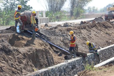 İnşaat işçileri proje üzerinde çalışıyorlar.