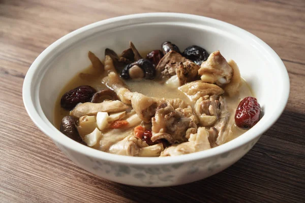 Chicken soup with wooden background