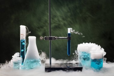 Glass tubes, beakers and flasks in the laboratory with fuming dry ice vapors. Sublimation of dry ice clipart