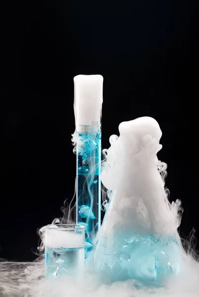 Dry ice in flasks with blue liquid. Sublimation of dry ice