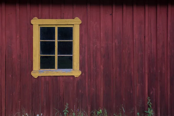 Czerwona drewniana ściana z żółtym oknem. Kopiuj przestrzeń. — Zdjęcie stockowe