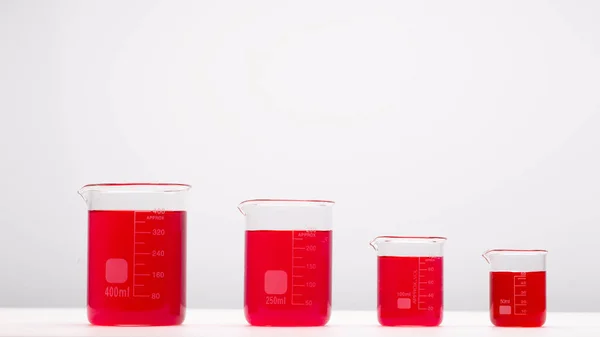 Equipo Laboratorio Vasos Precipitados Llenos Líquido Rojo Mesa Blanca Concepto —  Fotos de Stock