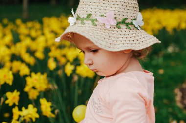 sevimli sarışın küçük kız sarı nergis bahar ülkede ile.