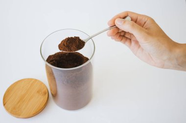 İnsan eli, kaşık ve kahve tutuyor..