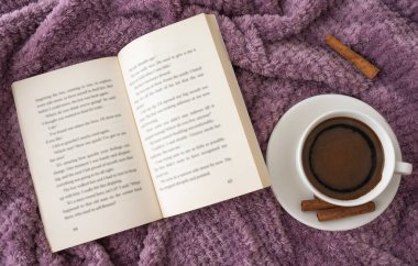 Mor madde yüzeyinde kitap ve kahve..
