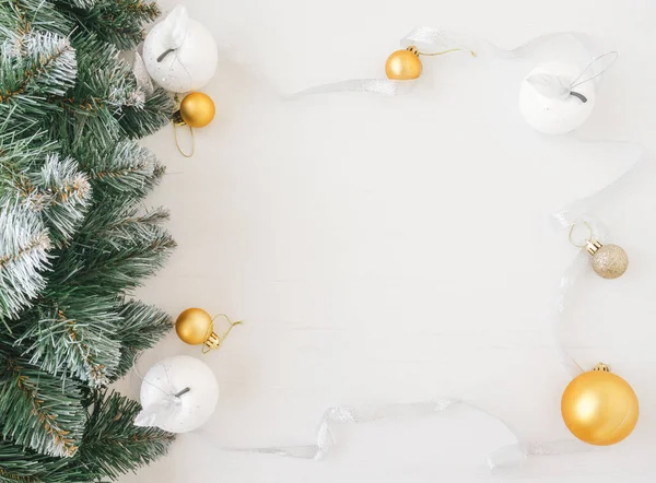 Beyaz kurdeleli ve noel ağacı dallı Noel oyuncaklarından yapılmış bir çerçeve. Noel konsepti.