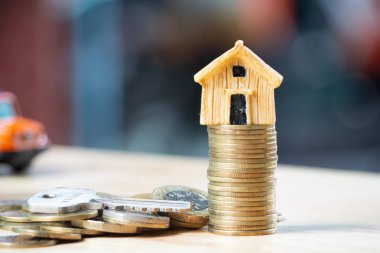 Ev veya ev modeli üzerinde yakın sikke yığını ile ev anahtarı. Kavramı kredi için mülkiyet merdiven, finans, mortgage, gayrimenkul yatırım, vergiler ve bonus.