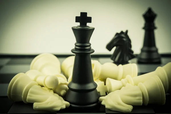 Black and White King and Knight of chess battle on board . Black king are leader to fight with teamwork to victory.  Leader and teamwork concept for success.